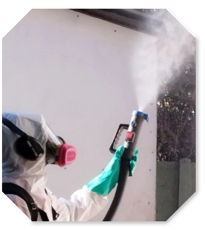 fumigacion-certificada-chile Persona fumigando utilizando traje de seguridad y mascarilla, aplicando producto con máquina.